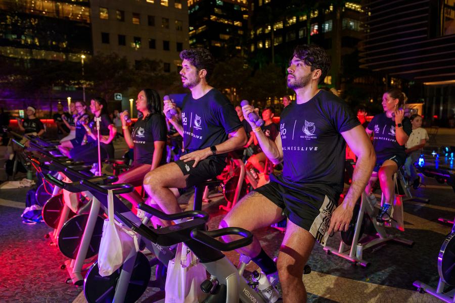 Turma pedalando junta sob as luzes dos prédios